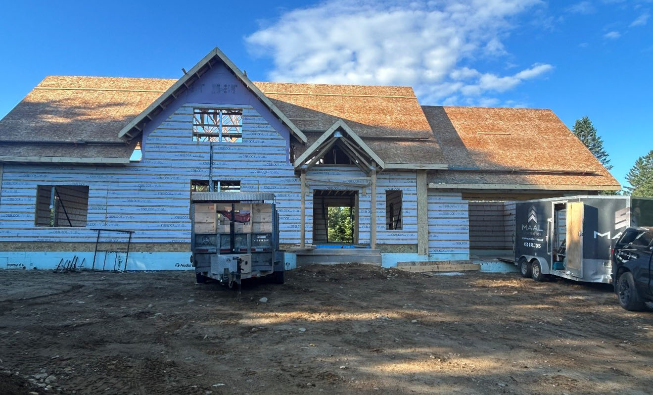 Maison en construction faite avec les blocs OSBLOCK, montrant la structure et les murs extérieurs avant la finition.